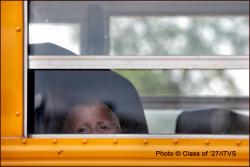 Little boy looking outside of school bus window
